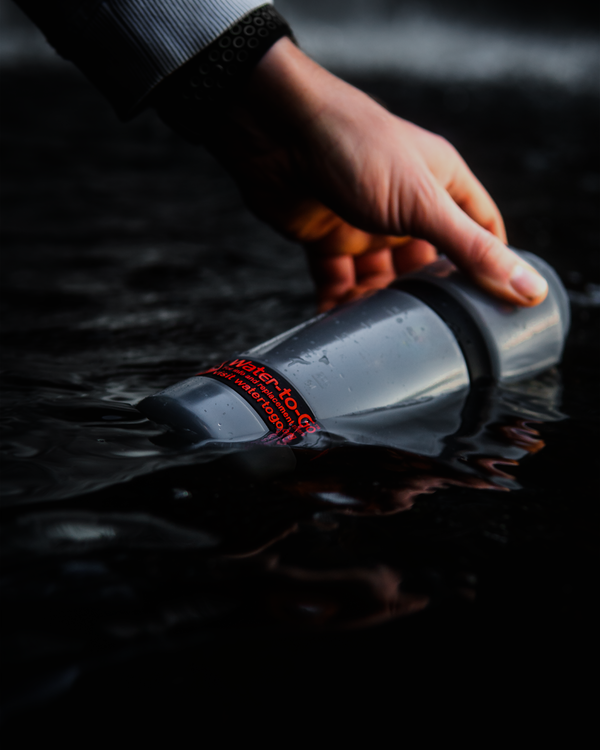 water filtration bottle being filled from a lake
