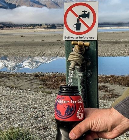 filling_Water_to_Go_Classic_water_filter_bottle_from_tap_with_sign_that_says__boil_water_before_use