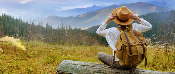 Woman in hat looking at mountains in distance