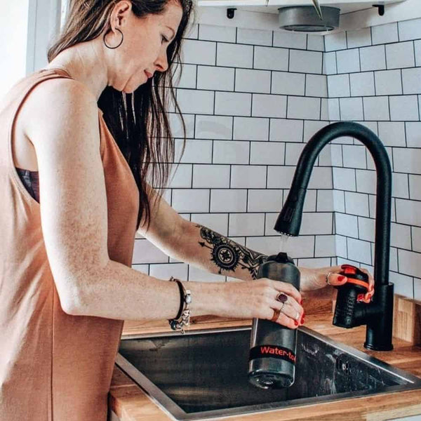 Woman filling Water to Go water filter bottle at sink