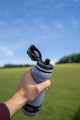 hand holding small water filtration bottle with lid open